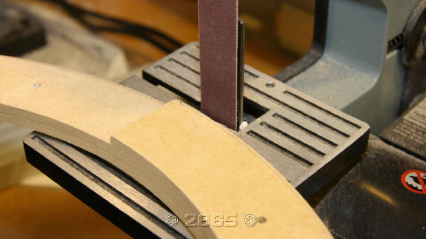 The bevel is made using a vertical sander. The support table is angled slightly so material is removed from the top edge.